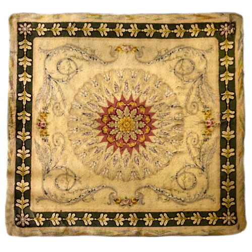 Sub.:6 - Lote: 278 - Alfombra en lana. Con rosetón central con motivo floral, circundado por roleos vegetales sobre campo beige y orla decorativa exterior oscura.